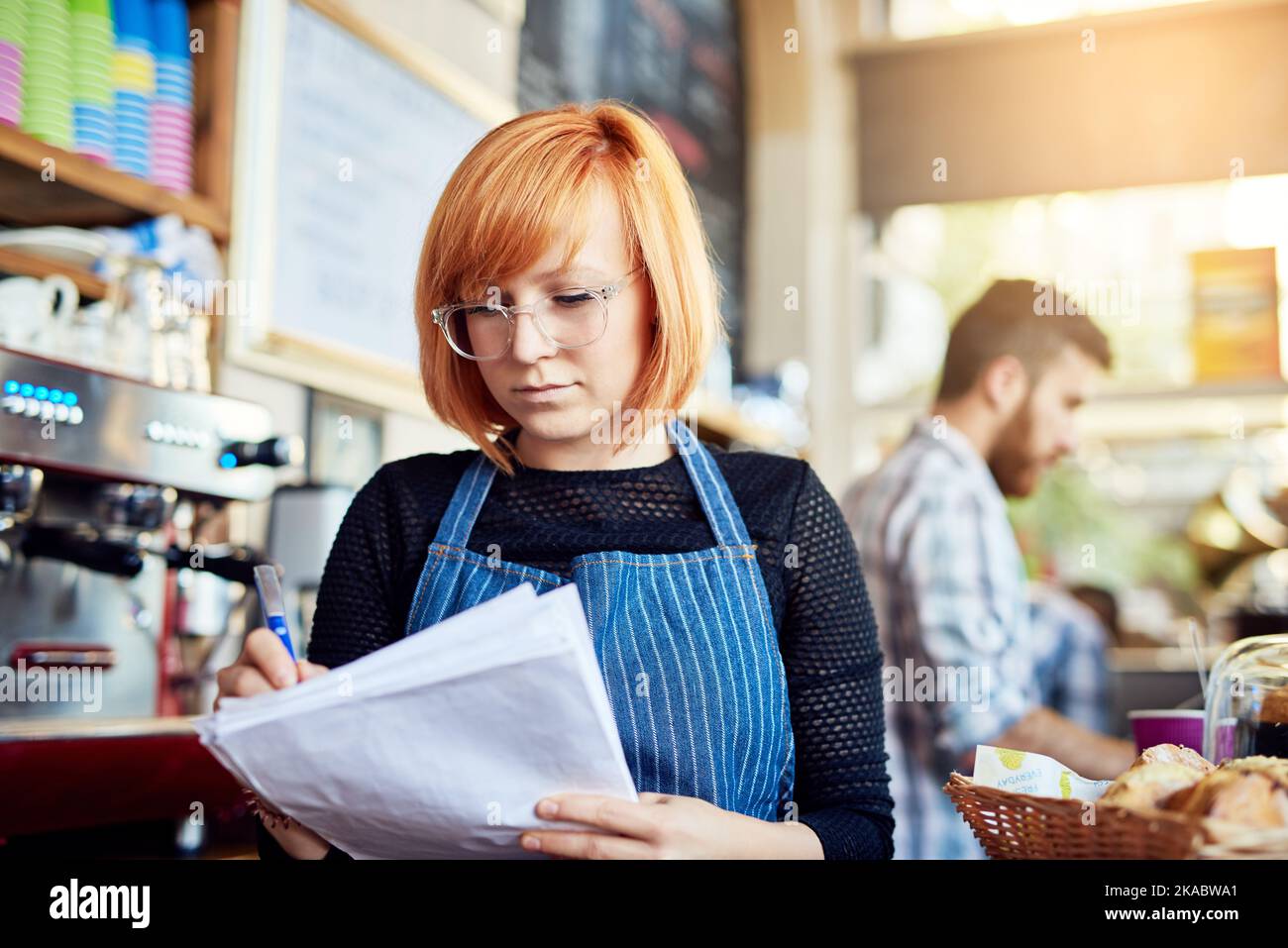 Assicurarci di non esaurire mai le scorte. Un proprietario di un negozio che fa dei documenti. Foto Stock