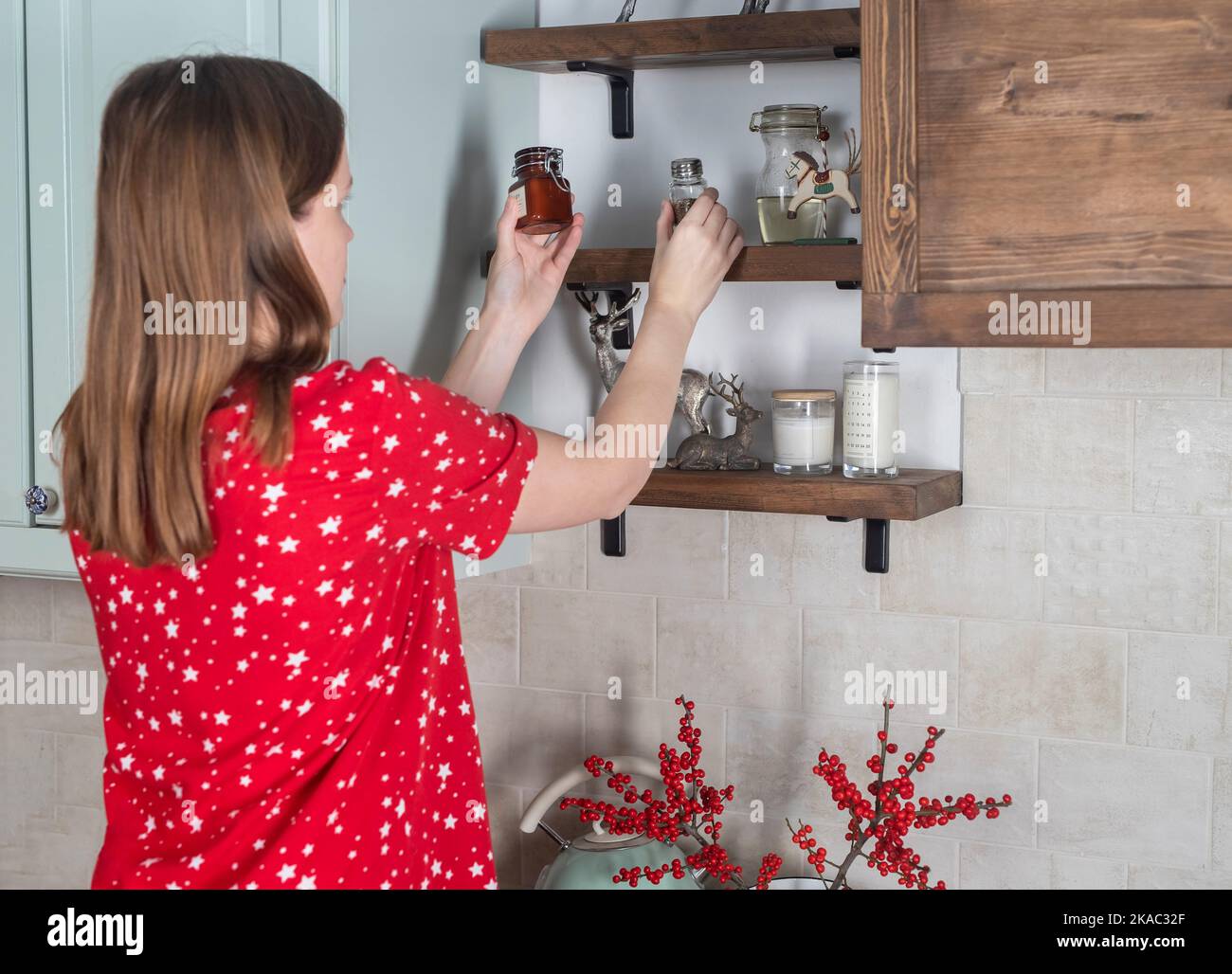 Giovane donna messo in ordine roba cucina a casa. Foto Stock