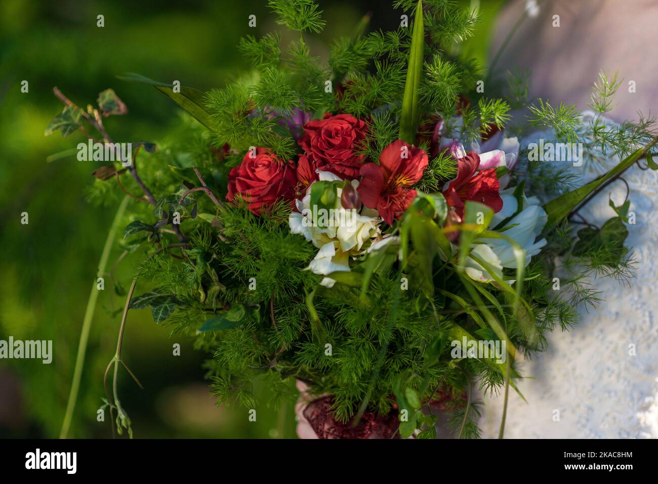 La sposa tiene un bouquet di nozze dalle rose nelle sue mani, fiori di giorno di nozze. Bel bouquet di fiori bohémien matrimonio. Ragazza in un abito con un bouq Foto Stock