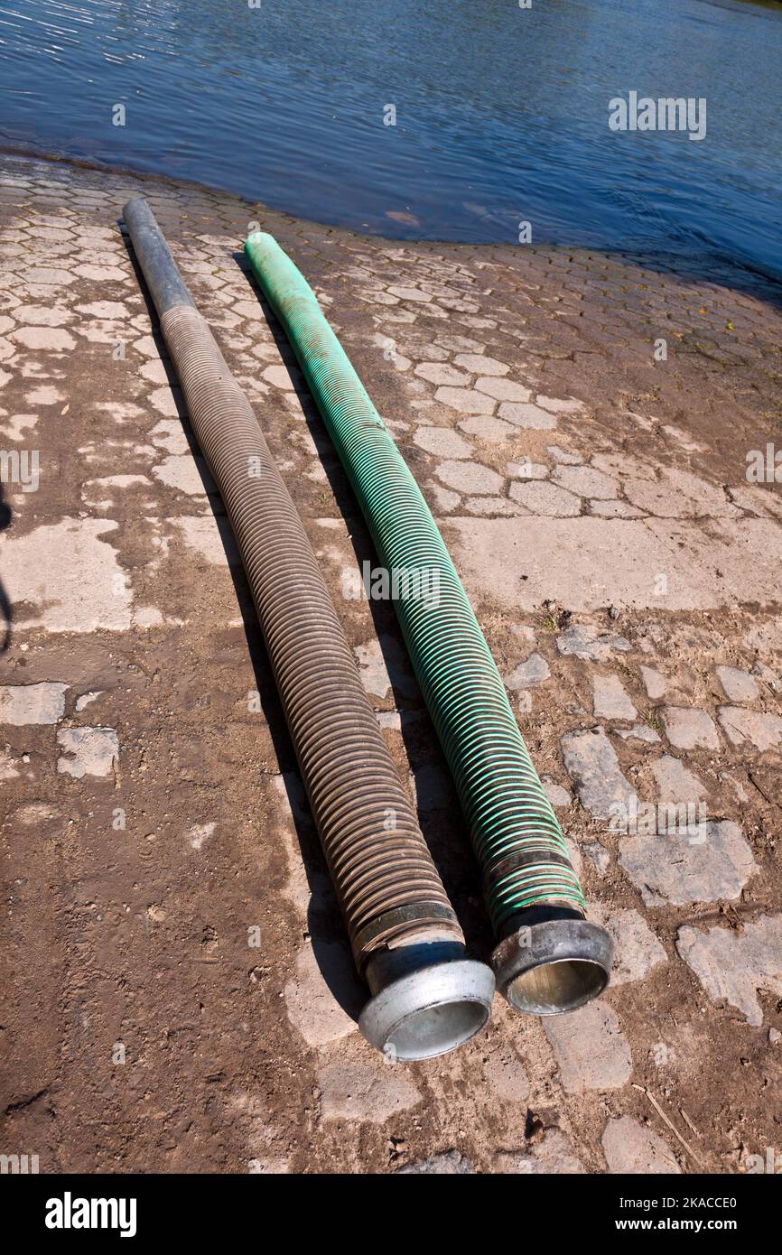 tubi flessibili per lo smaltimento del concime liquido nel fiume Foto Stock