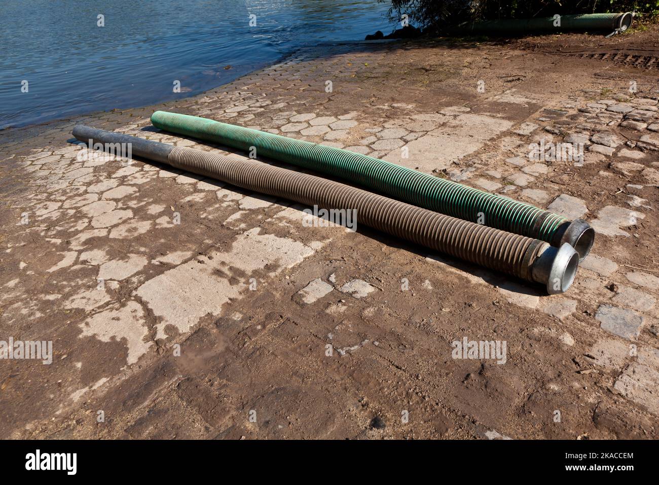 tubi flessibili per lo smaltimento del concime liquido nel fiume Foto Stock
