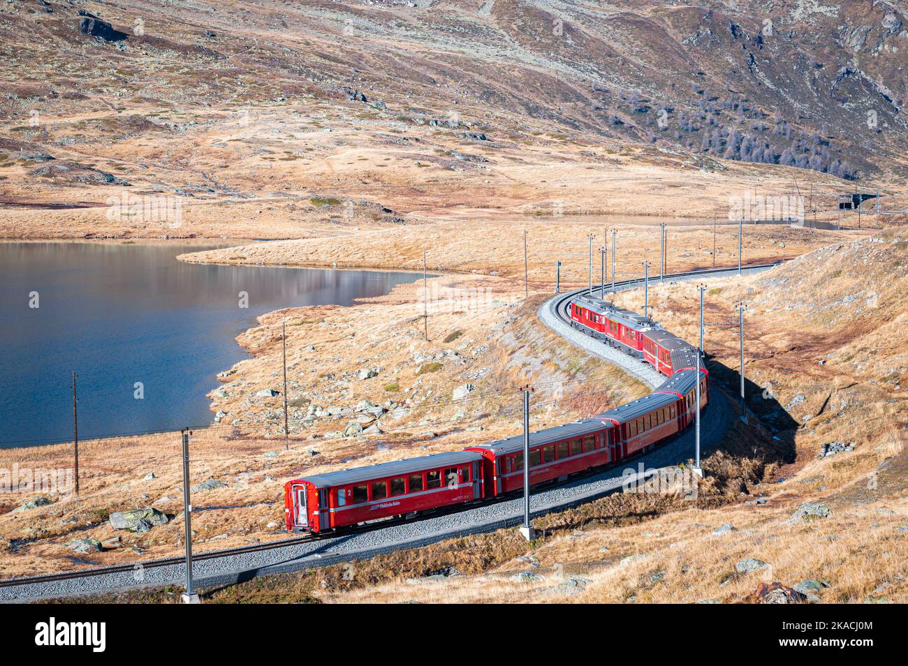 Vista panoramica di un treno rosso nelle Alpi svizzere della compagnia ferroviaria Rhätische Bahn. Foto Stock