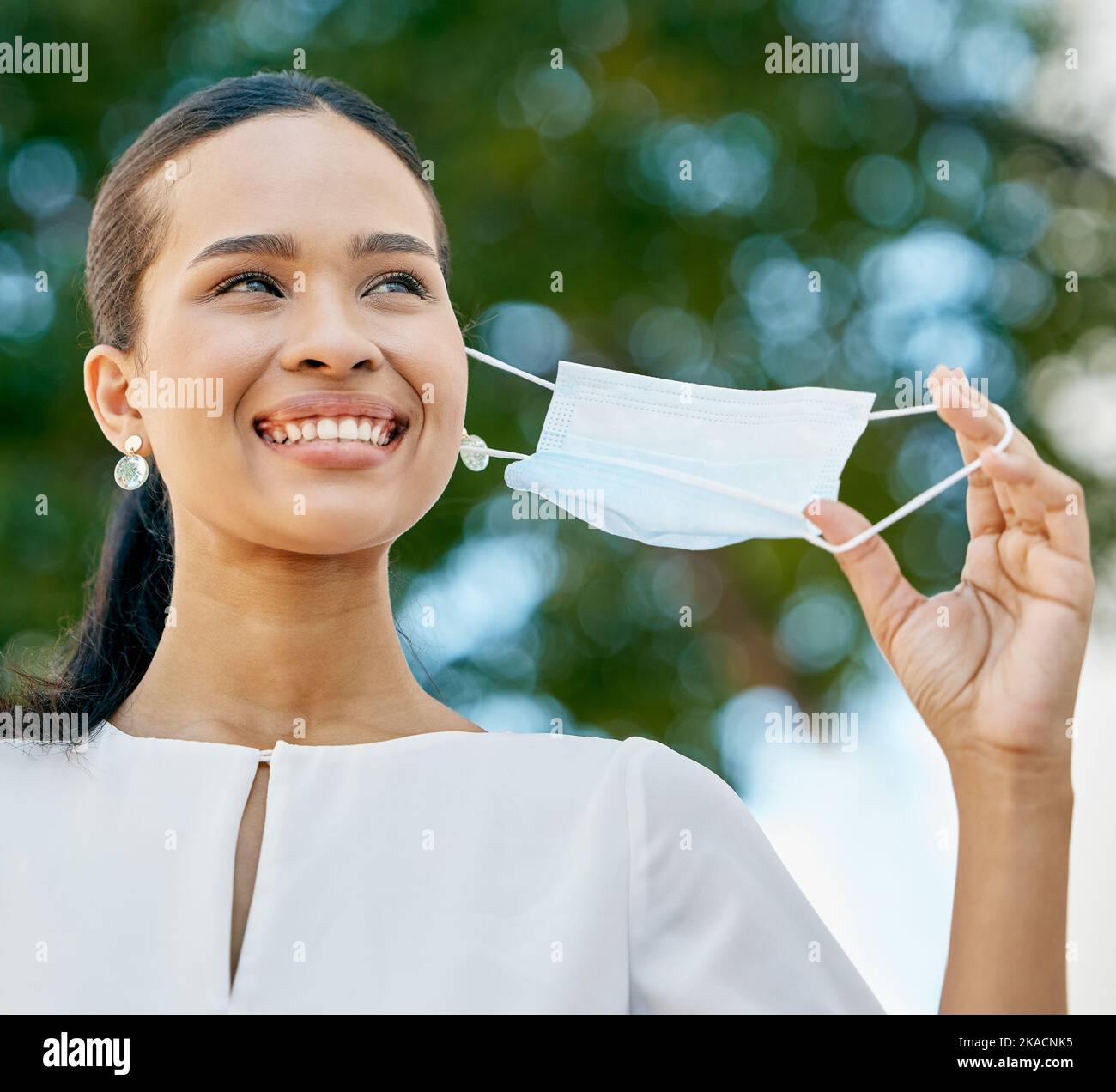 Covid, donna nera e take off maschera per la fine della pandemia, essendo felice e all'aperto protetto. Corona, giovane femmina e rimuovere il coperchio per l'aria fresca Foto Stock