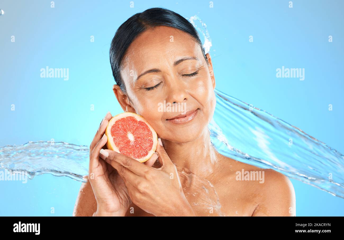 Spruzzi d'acqua, frutta e cura della pelle benessere di una donna con un pompelmo sensazione di salute e bellezza. Dieta, nutrizione e pelle sana di un modello con Foto Stock