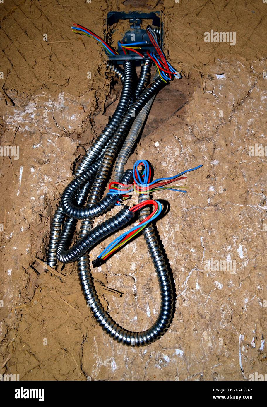 Elettrico esposto cavi collegati da un impianto elettrico in casa ristrutturata rustica Foto Stock