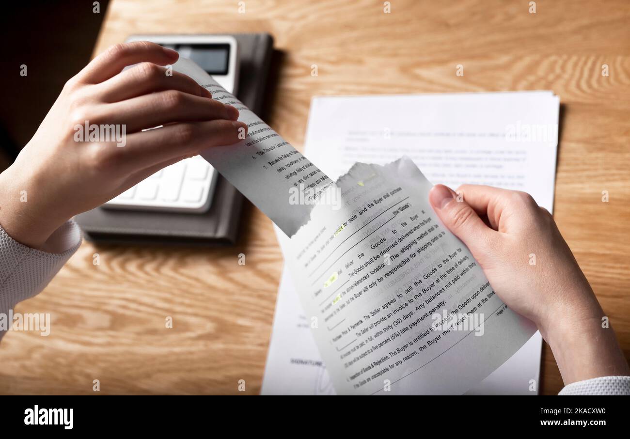 Concetto di risoluzione del contratto. Mani che violano e strappano l'accordo commerciale legale. Foto Stock