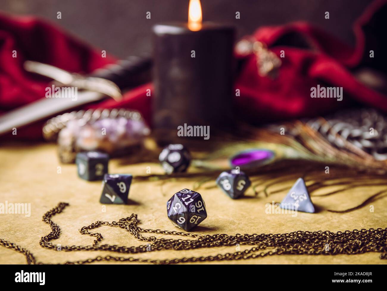 Gioco di ruolo fantasy gioco da tavolo ancora vita concetto. Focalizzazione selettiva sui dadi. Sfondo decorato con vari oggetti carattere strumenti. Foto Stock