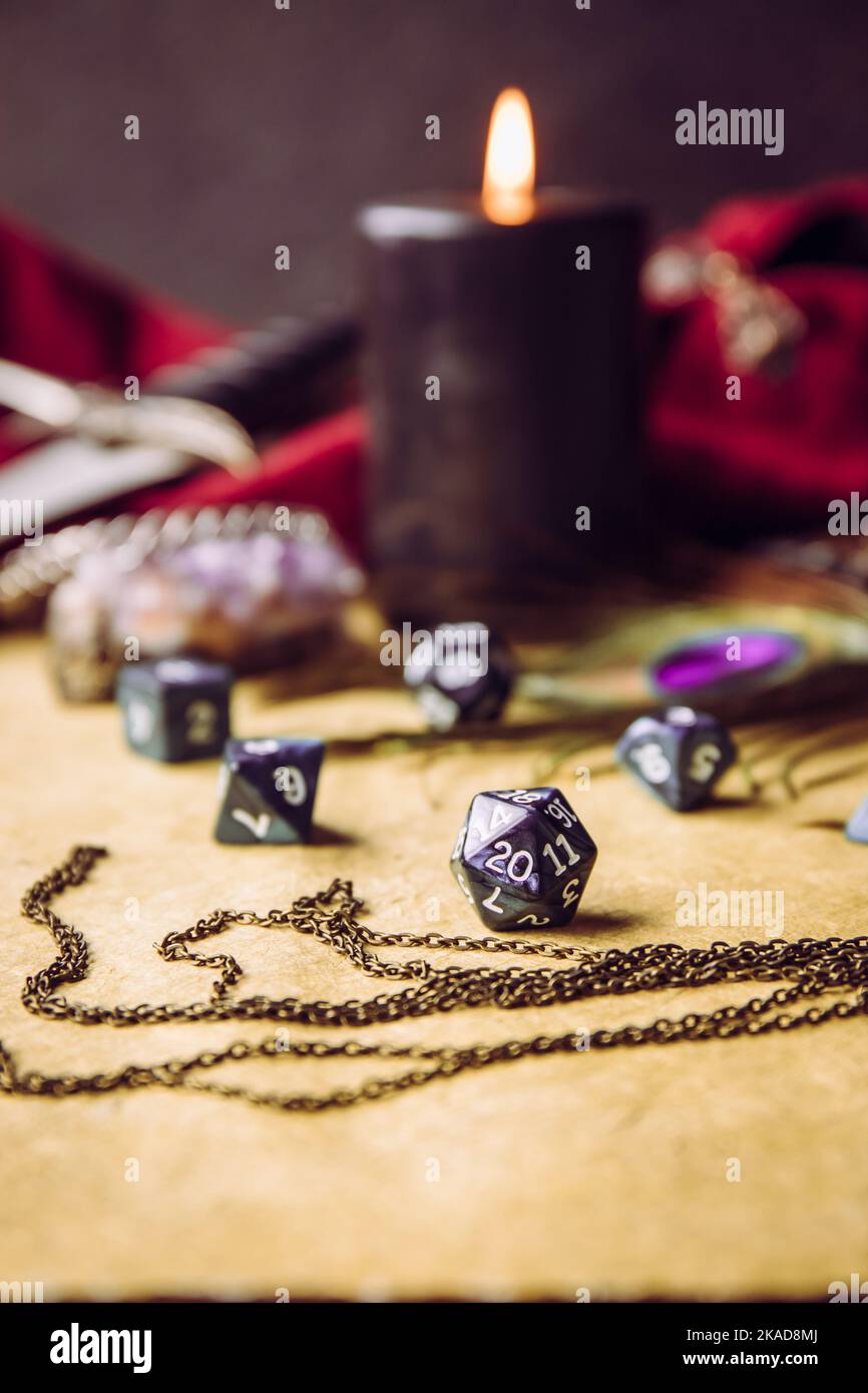 Gioco di ruolo fantasy gioco da tavolo ancora vita concetto. Focalizzazione selettiva sui dadi. Sfondo decorato con vari oggetti carattere strumenti. Foto Stock
