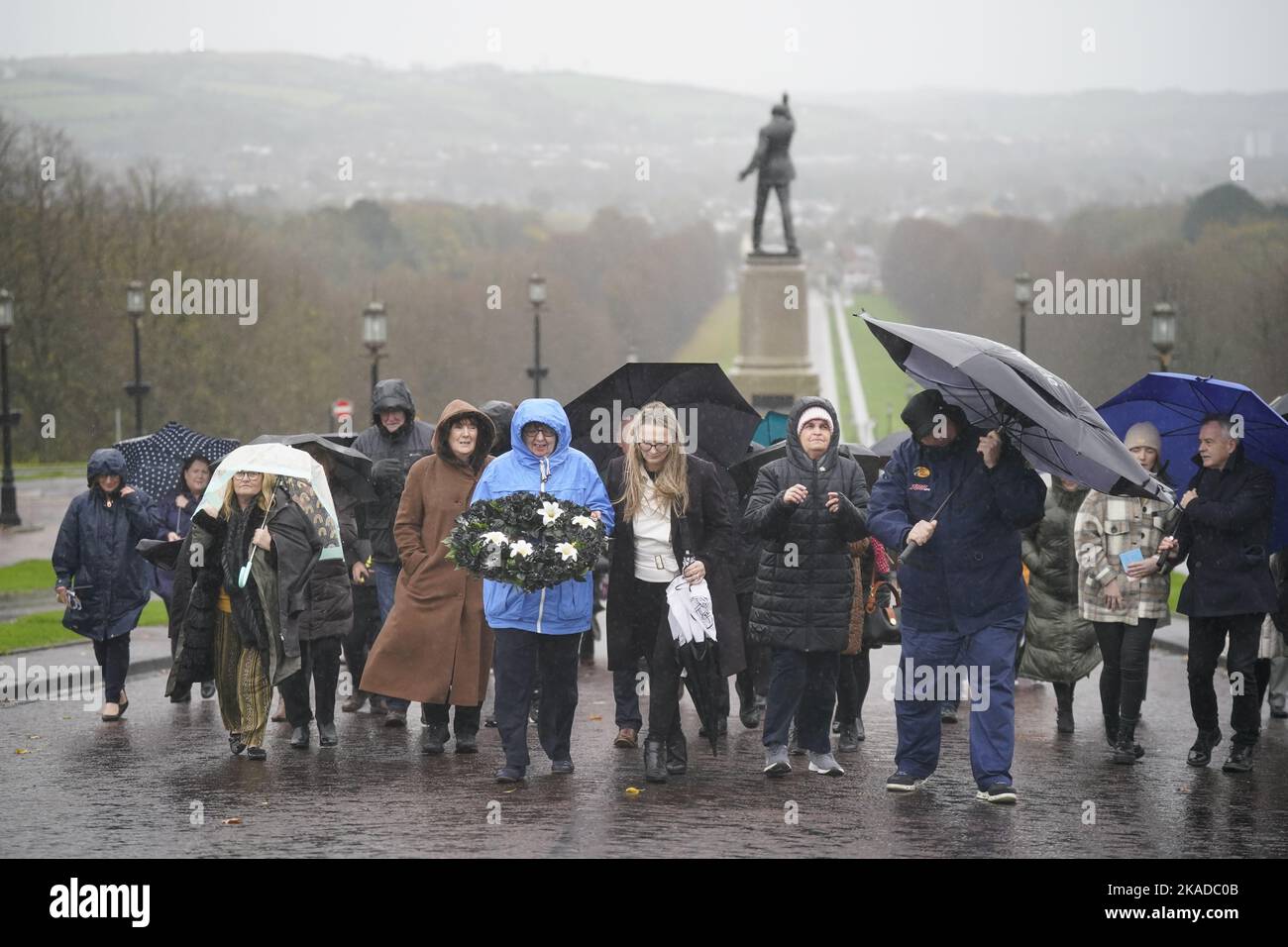 Dympna Kerr (in blu), sorella di Columba McVeigh porta una corona con il senatore irlandese Emer Currie (al centro a destra) mentre guidano un gruppo sulla 16th annuale All Souls Silent Walk per i scomparsi a Stormont. Data immagine: Mercoledì 2 novembre 2022. Foto Stock