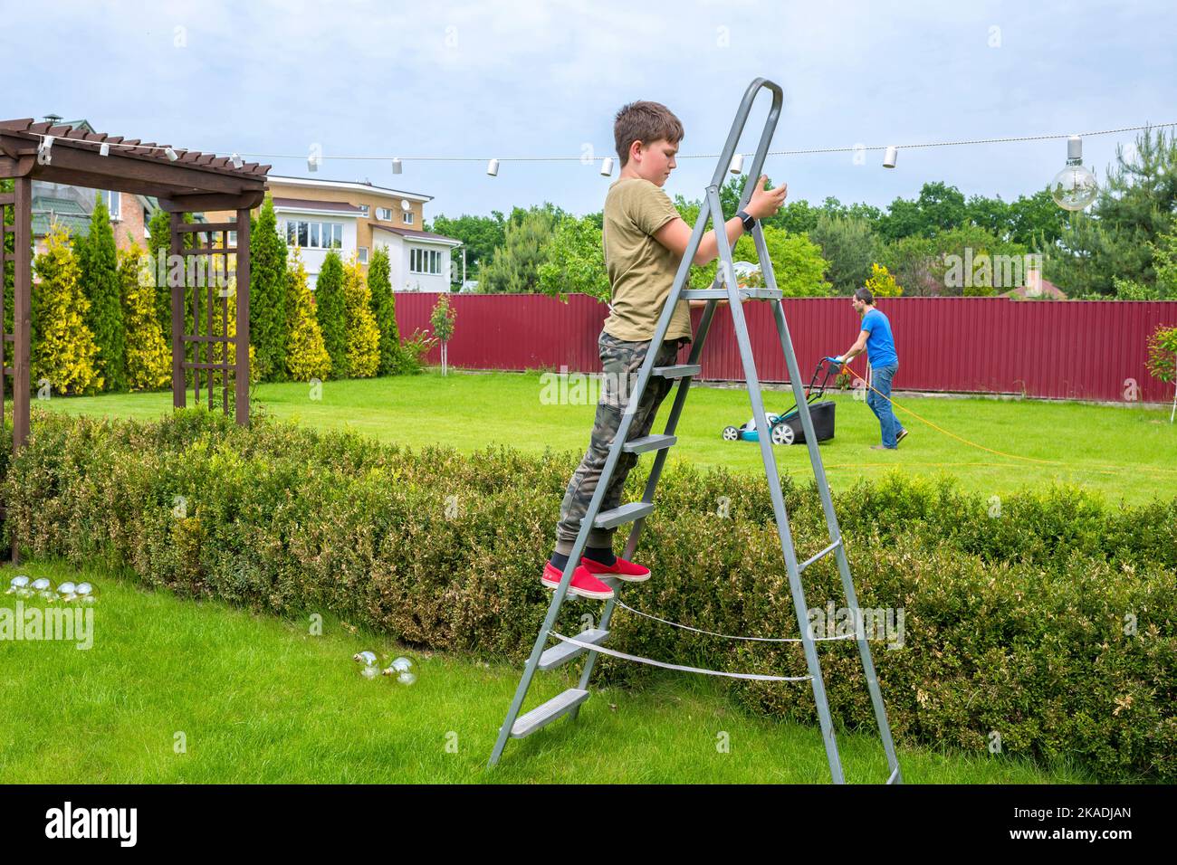 Giardino di lavoro. Un ragazzo con suo padre sta lavorando nel cortile Foto Stock