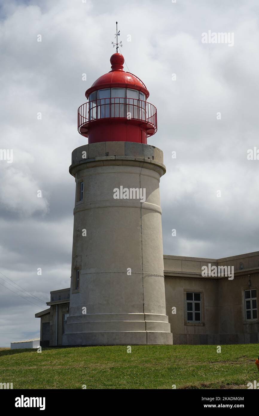 Uno scatto verticale del faro di Ponta do Albernaz (Farol de Albarnaz) contro il cielo nuvoloso in piena luce del sole a Flores Island, Azzorre, Portogallo Foto Stock