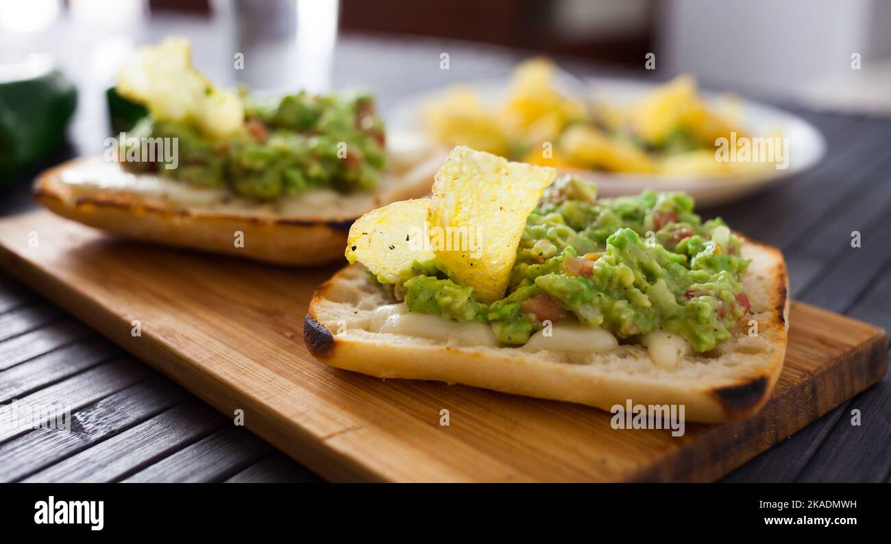 colazione sana, pane tostato ciabatta italiano con formaggio fuso e purea di avocado Foto Stock