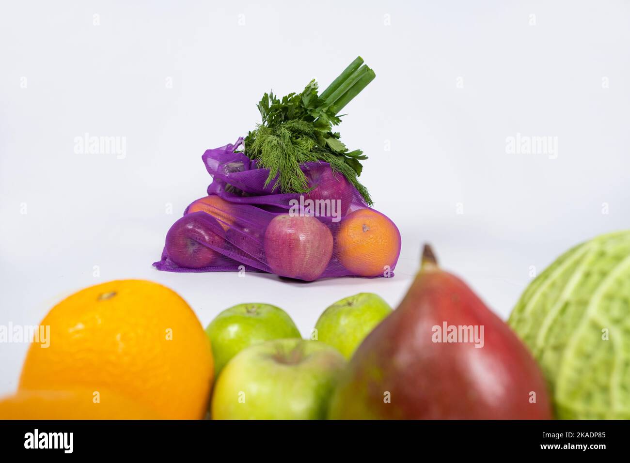 Rete in tessuto per frutta e verdura su fondo bianco. Un'alternativa riutilizzabile ai sacchetti di plastica. Foto Stock