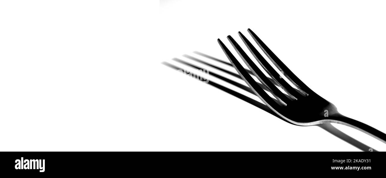 Forchetta singola isolata su sfondo bianco con ombra che rappresenta un'elegante cena su cibo raffinato Foto Stock