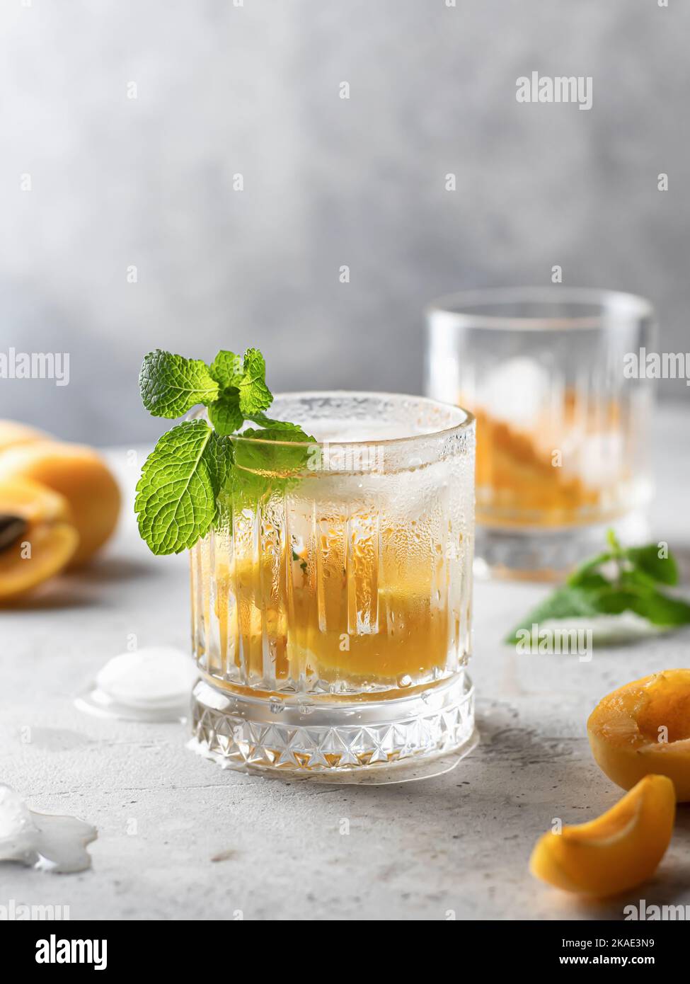 Cocktail ghiacciati all'albicocca e alla menta su sfondo grigio. Rinfrescanti cocktail estivi alcolici o analcolici. Disintossicare l'acqua infusa Foto Stock