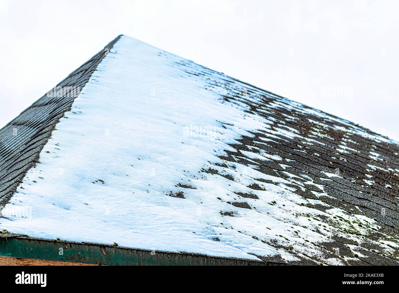 Un sottile strato di neve sulla tegola del tetto. Concetto di tempo invernale. Foto Stock