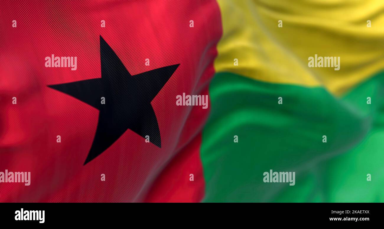 Vista ravvicinata della bandiera nazionale della Guinea-Bissau. La Repubblica di Guinea Bissau è uno Stato dell'Africa occidentale. Sfondo a trama di tessuto. Focus selettivo Foto Stock