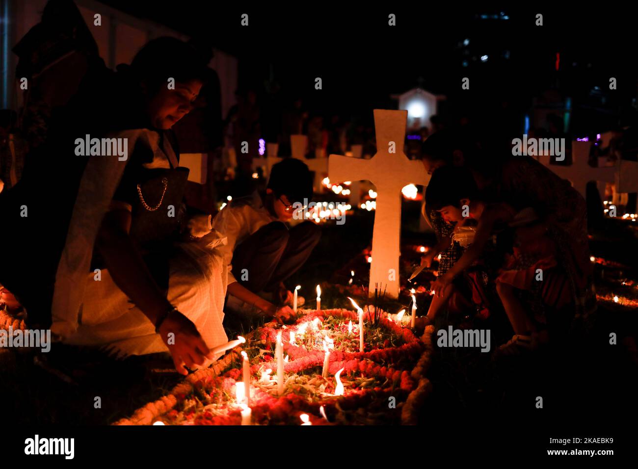 Dhaka, Bangladesh. 2nd Nov 2022. I cristiani cattolici di tutto il mondo osservano la Giornata dell'anima intera che celebra una giornata di preghiere per la pace dei morti, il secondo giorno di novembre di ogni anno. I devoti cristiani hanno messo ghirlande e candele accese nel cimitero dopo le preghiere della sera nella chiesa del Santo Rosario, Tejgaon a Dhaka, Bangladesh. (Credit Image: © Md. Rakibul Hasan/ZUMA Press Wire) Credit: ZUMA Press, Inc./Alamy Live News Foto Stock