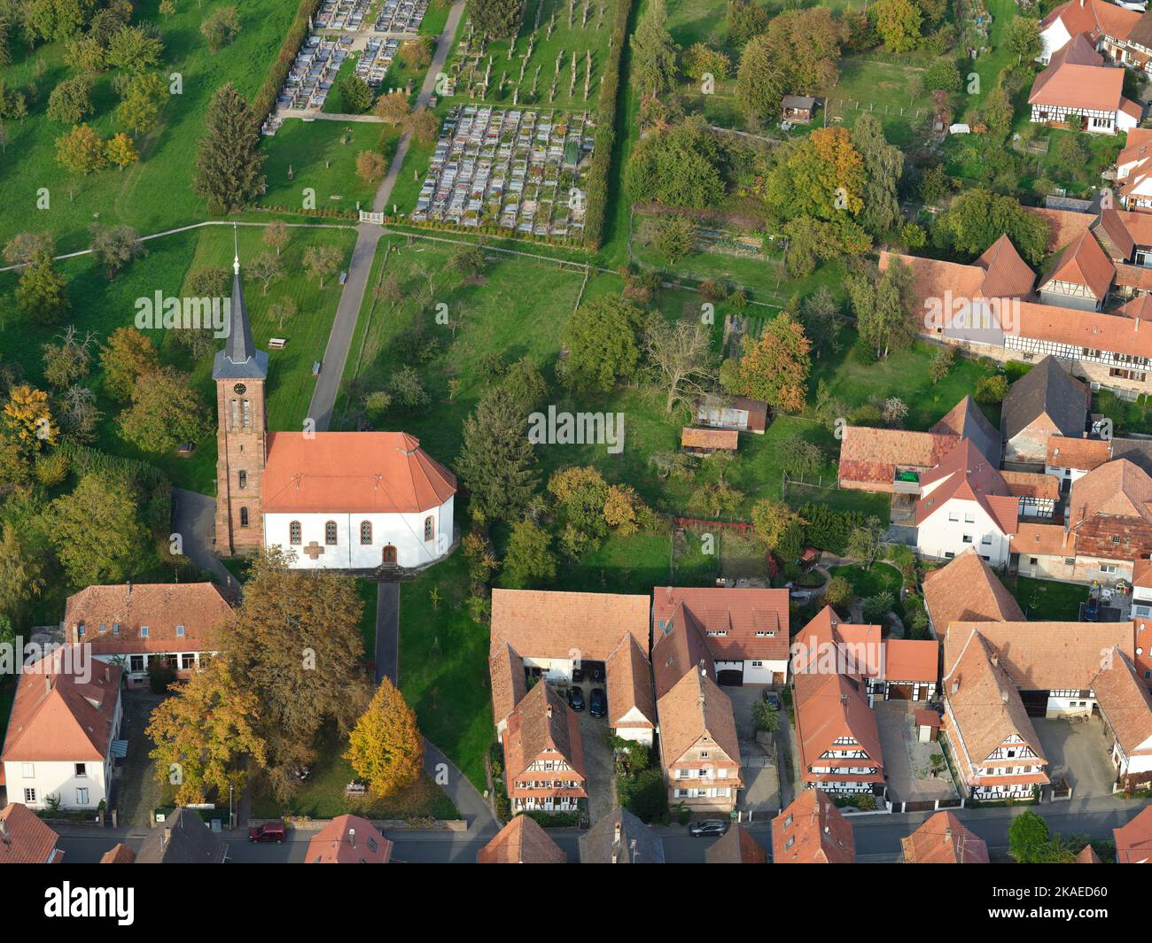 VISTA AEREA. Chiesa protestante che domina 'Rue principale' con le sue case uniche a graticcio. Hunspach, Bas-Rhin, Alsazia, Grand Est, Francia. Foto Stock