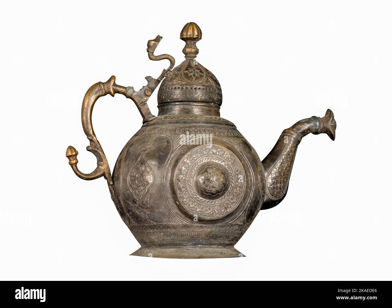 Una teiera in metallo antico con incisioni e inseguono artistiche su sfondo bianco Foto Stock