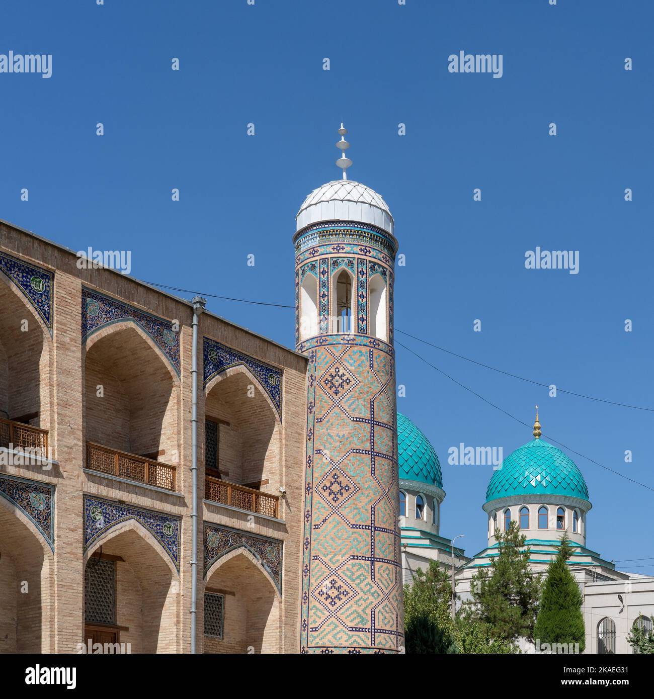 Vista panoramica degli archi e del minareto con decorazioni in piastrelle blu dell'antica madrasa di Kukeldash con la moschea di Juma o Dzhuma sullo sfondo, Tashkent, Uzbekistan Foto Stock