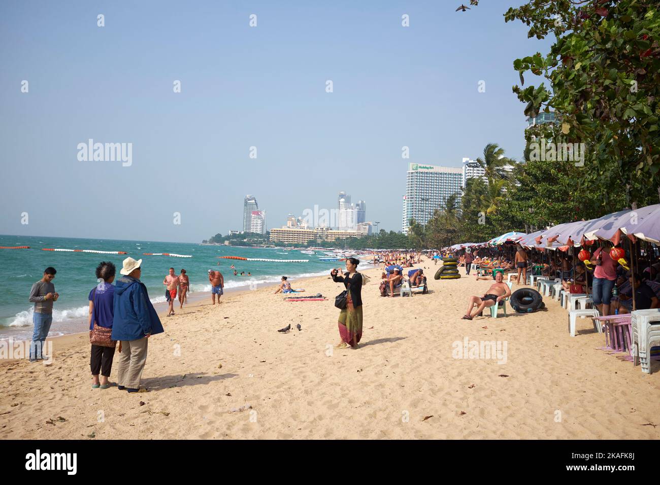 I vacanzieri in posa per foto ricordo sulla spiaggia di Pattaya, Thailandia Foto Stock