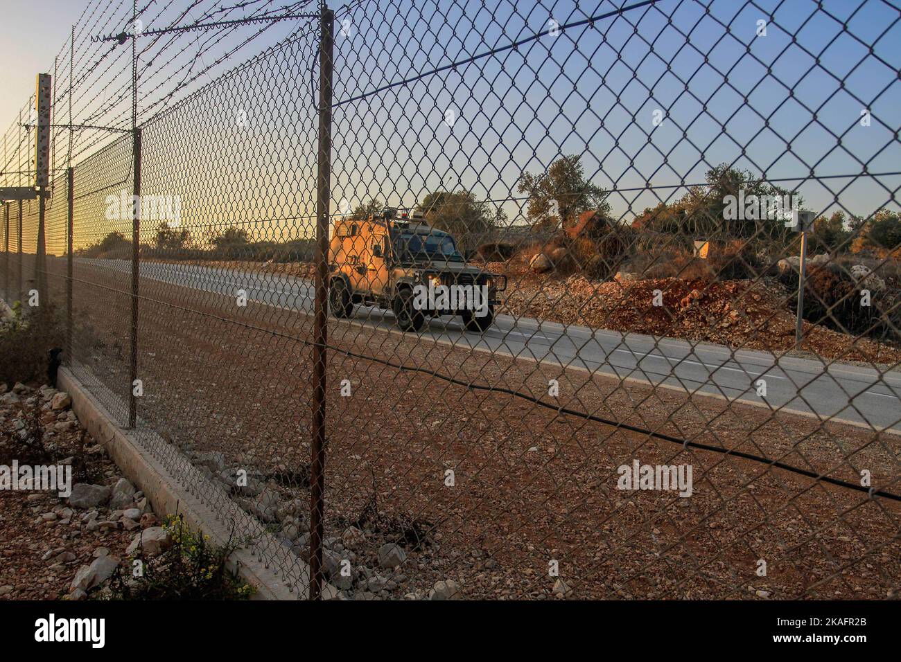 Un veicolo militare israeliano trasporta i soldati fino alla porta della barriera di separazione nella Cisgiordania occupata a nord per aprire la porta affinché gli agricoltori palestinesi entrino nelle loro terre confiscate da Israele. Gli agricoltori palestinesi hanno chiuso le porte situate sul muro che separava la città di Salfit e l'insediamento ebraico di Ariel per raggiungere le loro terre confiscate per raccogliere le olive, Dopo che l'esercito israeliano li ha aperti alle sette del mattino e li ha chiusi fino alle quattro della sera e li ha riaperti per consentire agli agricoltori di andarsene. Foto Stock