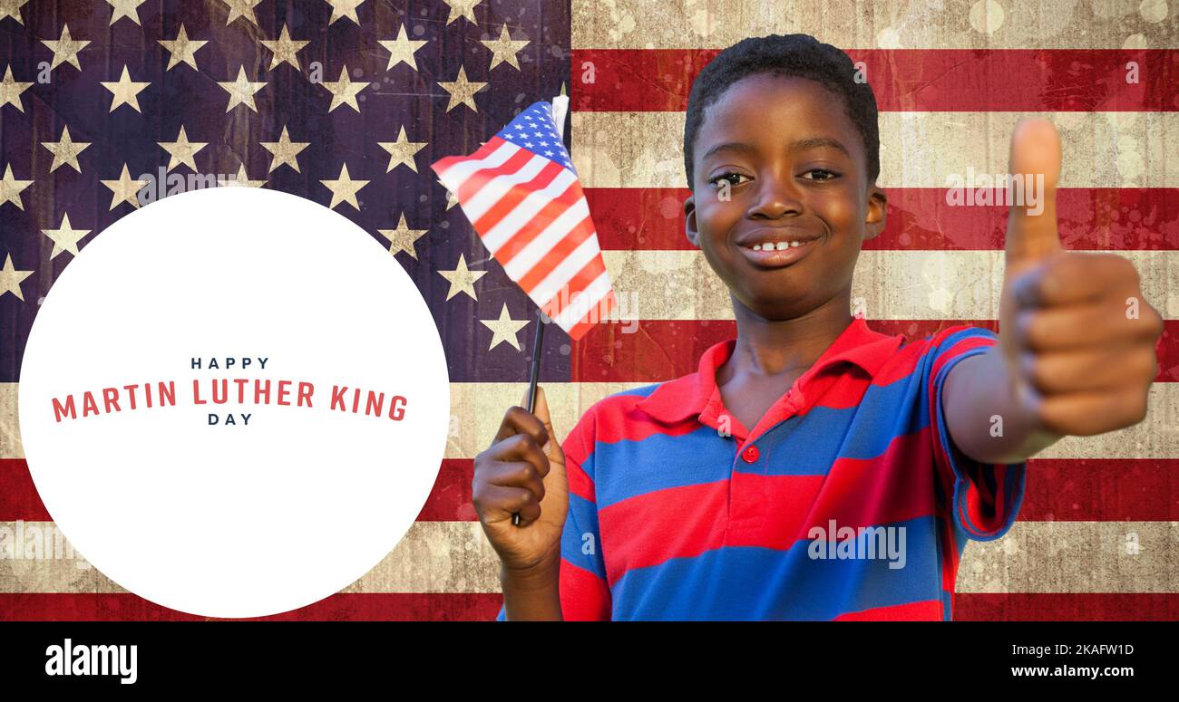 Sorridente ragazzo afroamericano con la bandiera degli stati uniti che mostra i pollici in su da martin luther re jr Day Foto Stock