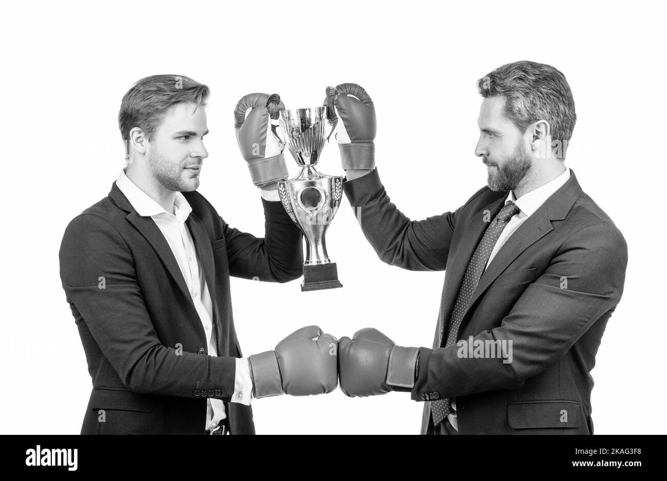 due uomini d'affari in guanti da boxe tengono champion cup dopo la battaglia aziendale per la leadership, la vittoria. Foto Stock