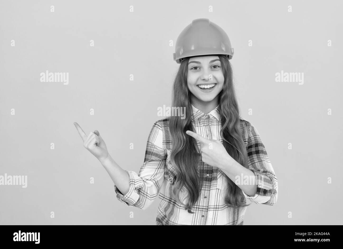 teen girl in casco. costruttore capretto in camicia a scacchi. costruzione e costruzione concetto. Foto Stock