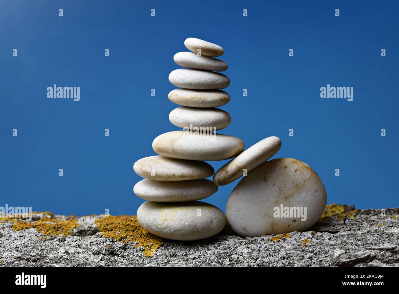Montón de piedras zen en equirio sobre fondo azul Foto Stock