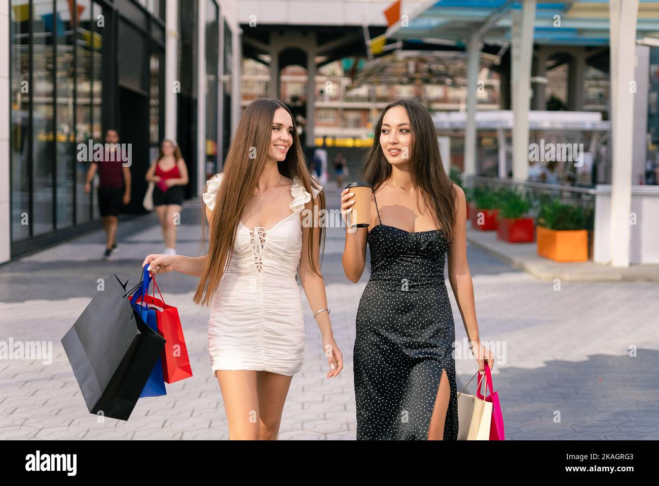 Donne eleganti che camminano per strada durante lo shopping Foto Stock