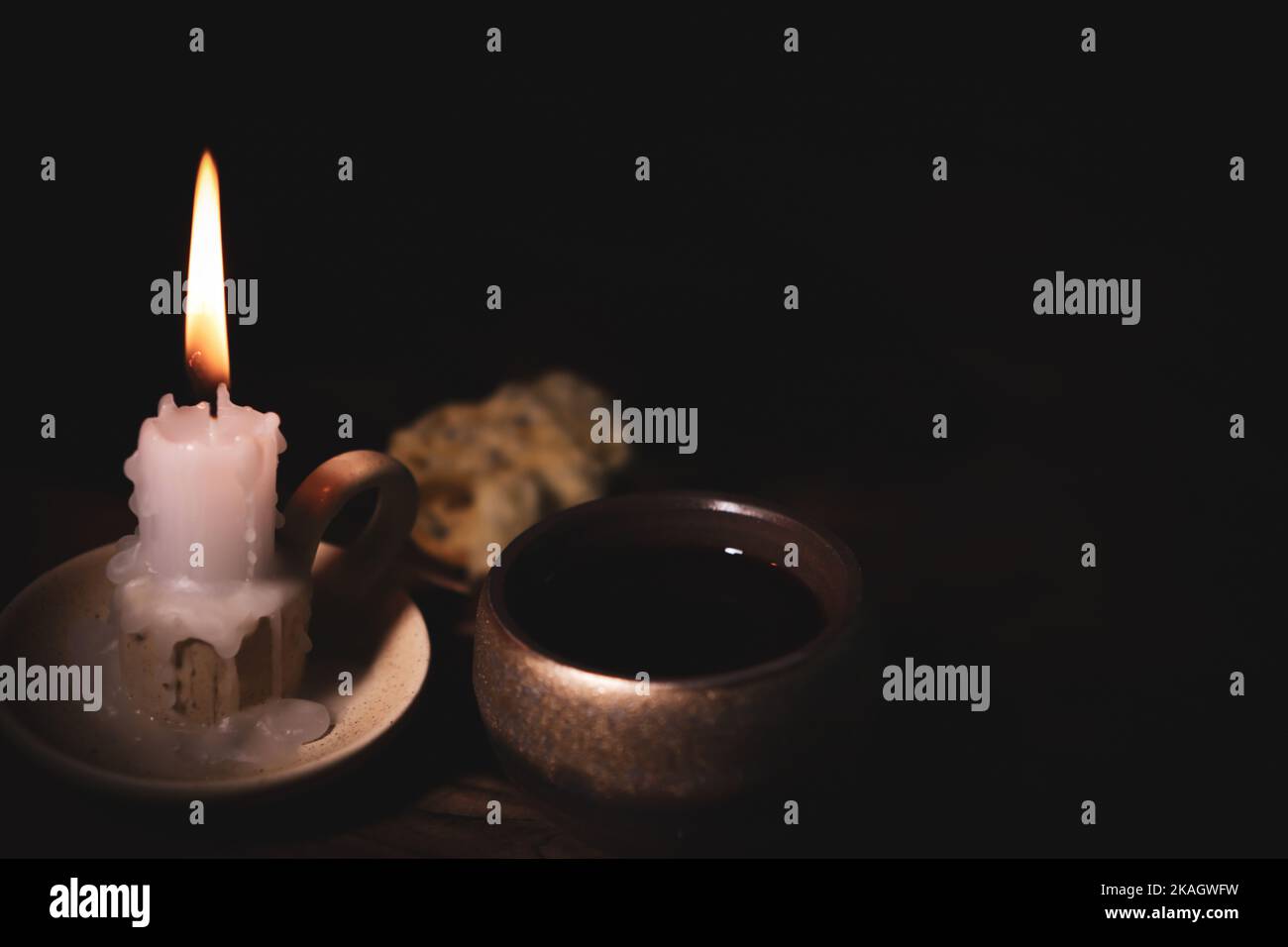 Santa comunione simboleggia il sangue e la carne di Gesù Cristo ultima cena vino, pane e una candela luminosa sul candelabro Foto Stock