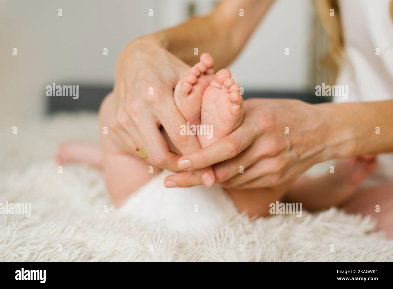 La madre tiene i piedi piccoli del bambino neonato. Buona maternità Foto Stock