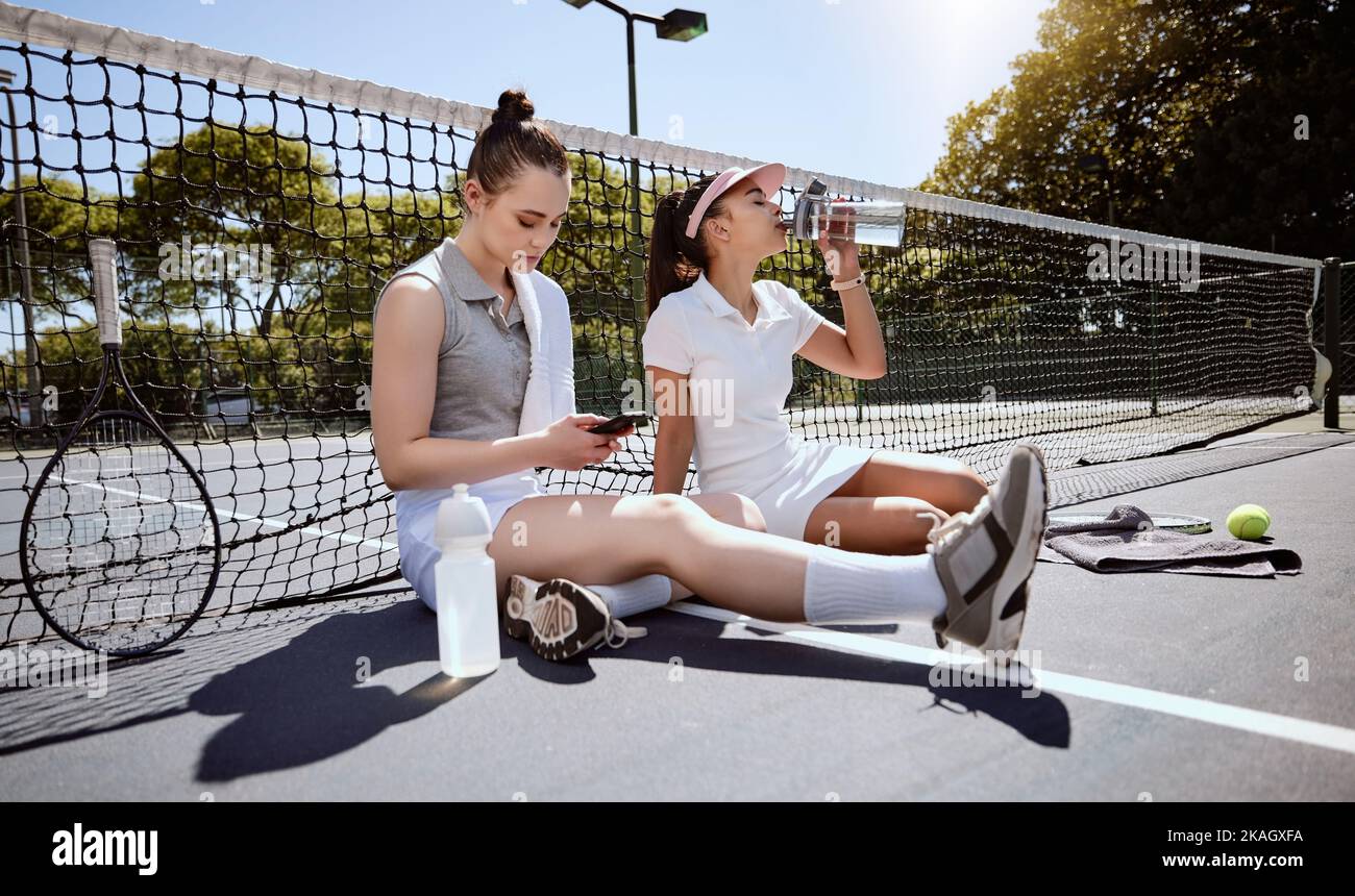 Donna, amici e tennis in pausa sportiva, relax o tempo fuori insieme sul campo all'aperto. Fitness donne in relax dopo il gioco sportivo, partita Foto Stock