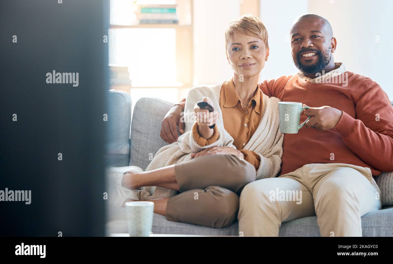 Telecomando per la coppia, la connessione o la televisione sul divano per film, spettacoli di casa o streaming multimediale nel soggiorno. Sorriso felice, donna nera o. Foto Stock