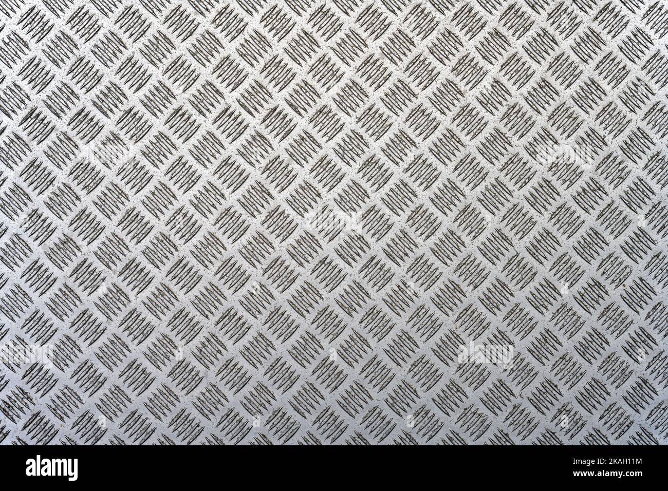 Uno sfondo metallico con un disegno della piastra del battistrada Foto Stock