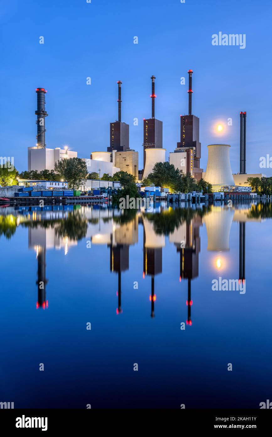 Una centrale elettrica a Berlino durante l'ora blu riflessa in un canale Foto Stock