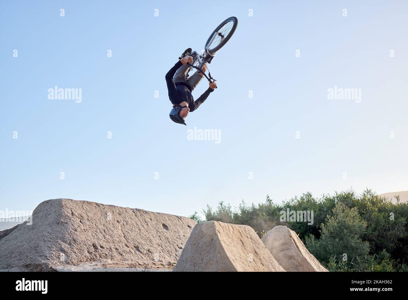 Mountain, bike e ciclista uomo in bicicletta per un rischio pericoloso acrobazie. Fitness, adrenalina junkie e sport estremi con un sano salto biker Foto Stock