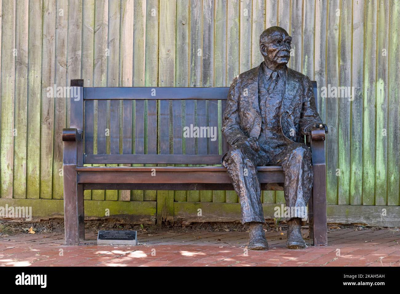 Statua a grandezza naturale di Rudyard Kipling di Victoria Atkinson seduta su una panchina a Burwash, East Sussex, Inghilterra, Regno Unito Foto Stock