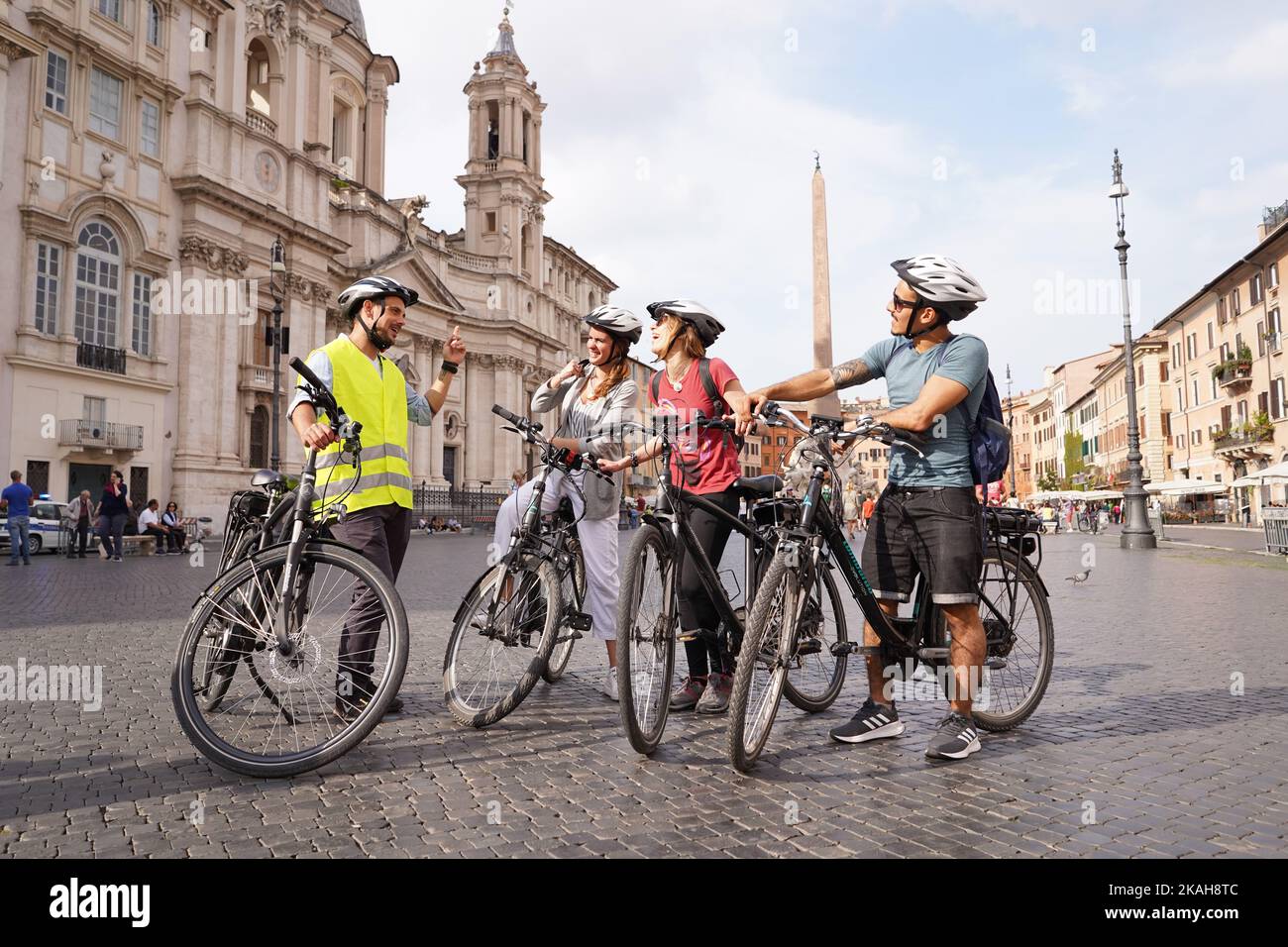 Giovani amici turisti a Roma che fanno un tour guidato in bicicletta in Piazza Navona Foto Stock