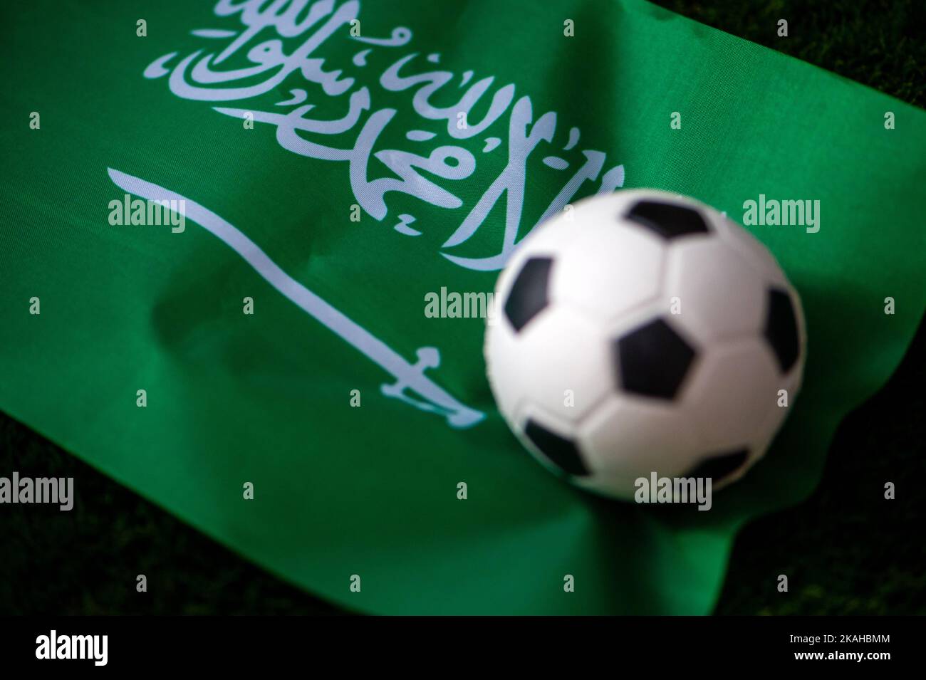Nazionale di calcio dell'Arabia Saudita. Bandiera nazionale su erba verde e palla da calcio. Carta da parati da calcio per Campionato e Torneo nel 2022. Mondo i Foto Stock