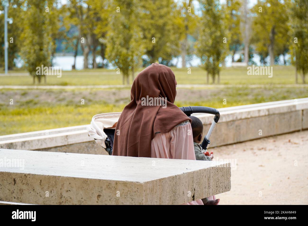 Mamma nera musulmana con il suo bambino nel parco. Migrazione in Spagna Foto Stock