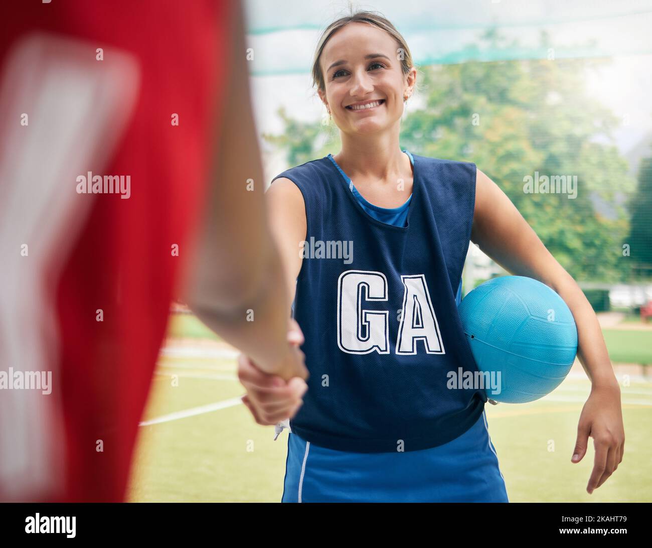 Handshake, sport e donne in netball scuotono le mani in una partita di allenamento o in una competizione all'aperto. Sorridete, rispettate e salutate i giocatori felici su un Foto Stock