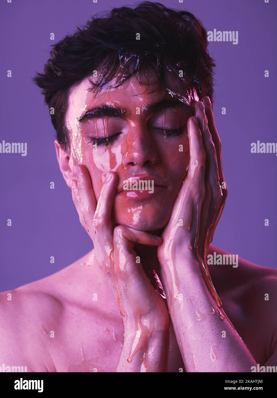 Viso, miele e uomo con cura naturale della pelle per la salute, lusso e cosmetici sullo sfondo viola studio. Benessere, creativo e giovane Foto Stock