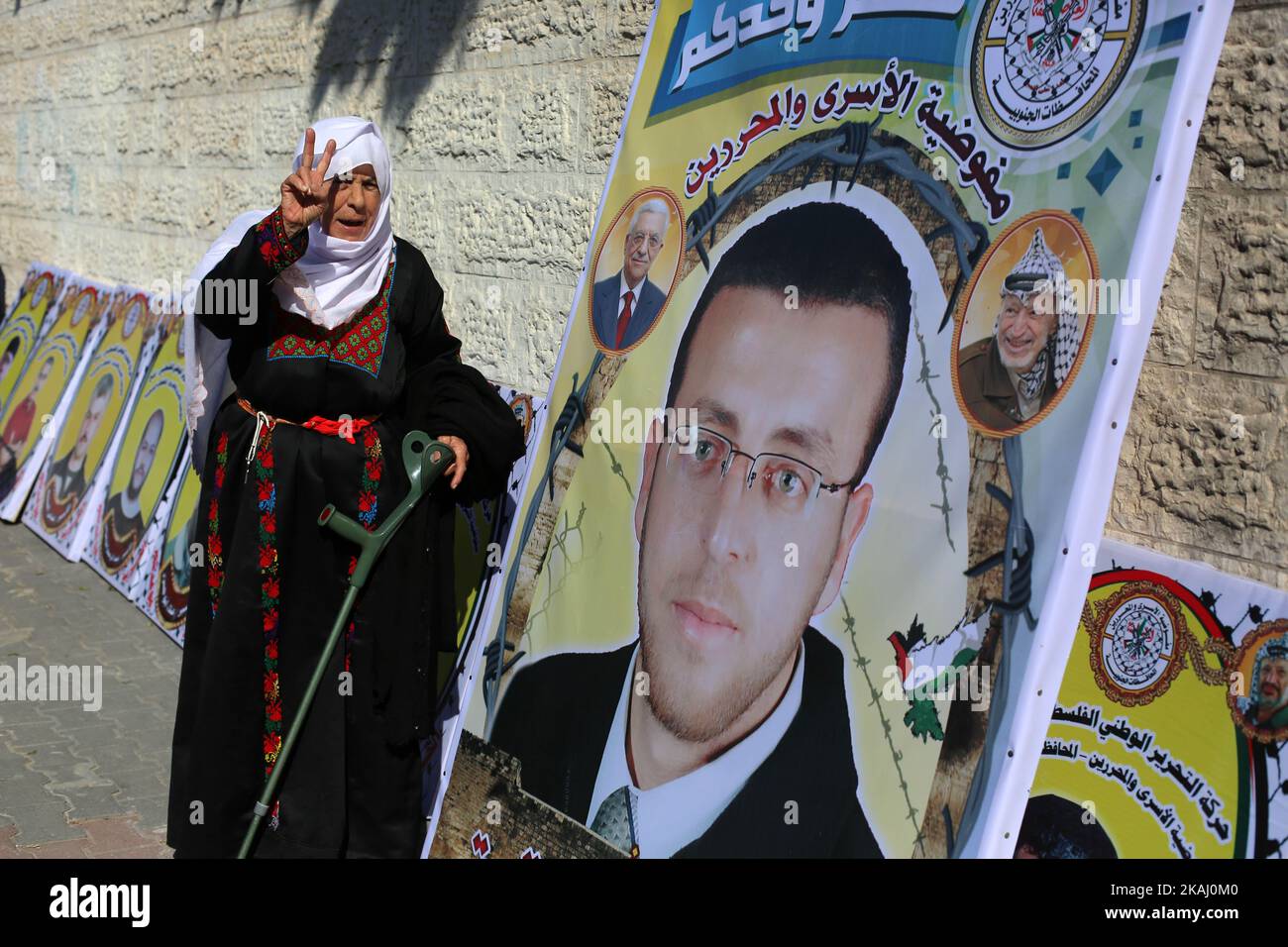 Un palestinese si trova accanto a un cartello con il ritratto del giornalista palestinese Mohammed al-Qiq, durante una manifestazione del 1 febbraio 2016 nella città di Gaza. Qiq, padre di 33 anni di due persone e corrispondente della rete televisiva Almajd dell'Arabia Saudita, è stato in sciopero della fame per 63 giorni durante la sua detenzione ai sensi della legge sulla detenzione amministrativa di Israele e i suoi organi sono a rischio di fallimento in qualsiasi giorno, dice il suo team legale. La Corte Suprema ha detto il 27 gennaio 2016 che non avrebbe rilasciato Qiq immediatamente, ma avrebbe seguito la sua salute su base giornaliera. (Foto di Majdi Fathi/NurPhoto) *** Please use Foto Stock
