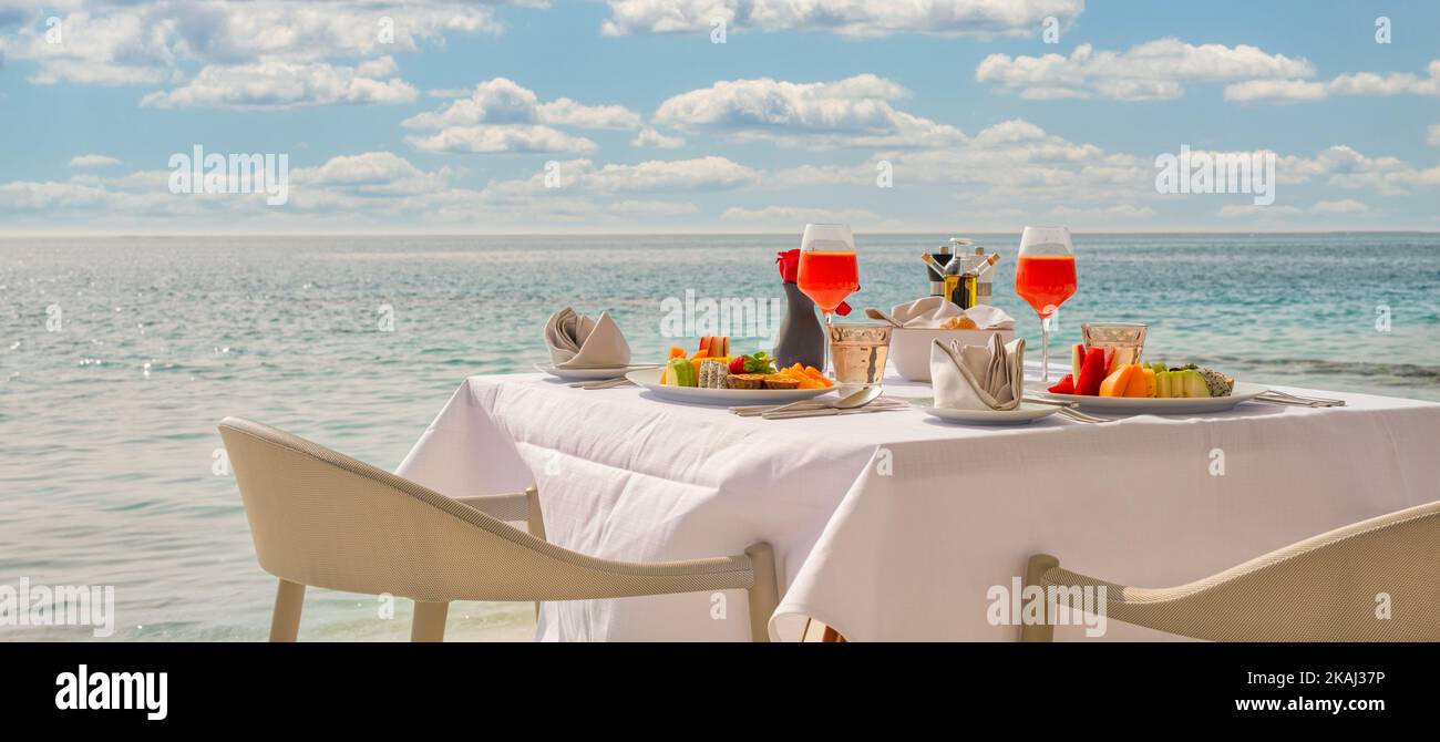 Tavolo per la colazione di lusso con cibo per due con splendida vista sul mare tropicale sullo sfondo. Mattina coppia tempo vacanza estiva e romantico concetto di vacanza Foto Stock