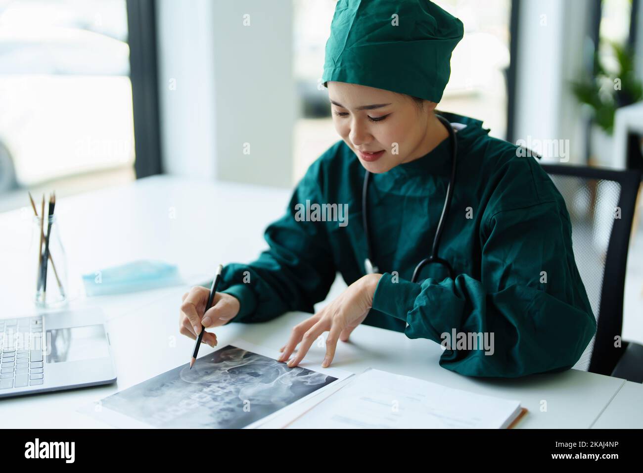 Ritratto di un medico asiatico che guarda la pellicola radiografica del paziente.. Ritratto di un medico asiatico che guarda la pellicola radiografica del paziente. Foto Stock