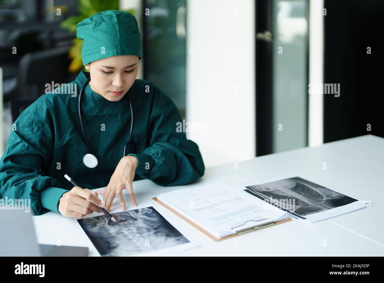 Ritratto di un medico asiatico che guarda la pellicola radiografica del paziente.. Ritratto di un medico asiatico che guarda la pellicola radiografica del paziente. Foto Stock