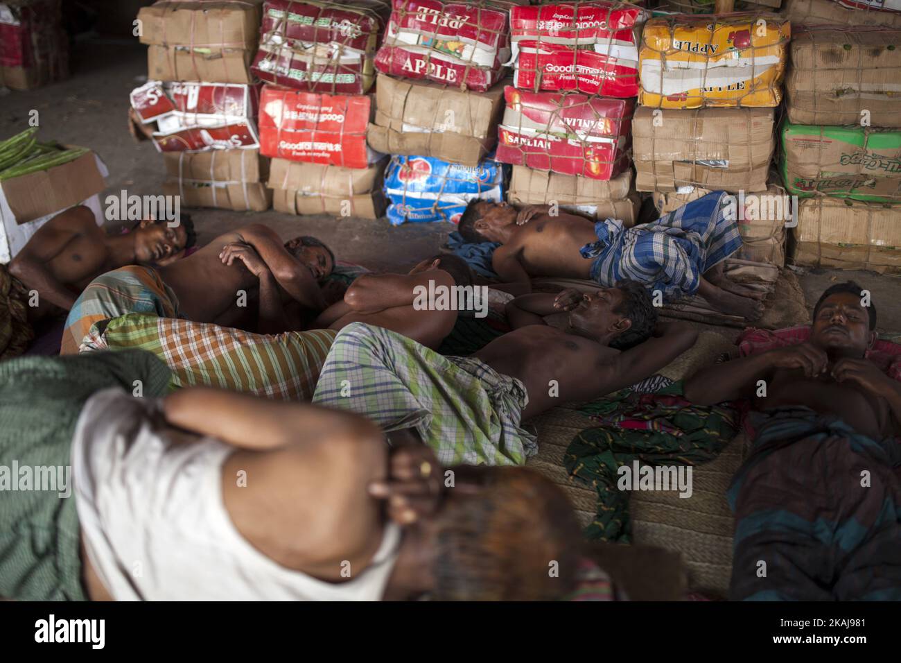 DHAKA, BANGLADESH - 12 MAGGIO: I lavoratori di Karwan Bazar pausa per una siesta di metà giornata per battere il caldo mezzogiorno d'estate nel loro posto di lavoro a Karwan Bazaar il 12 maggio 2016 a Dhaka, Bangladesh. Con i prodotti che arrivano a mezzanotte, il vagliamento e la vendita si estendono fino al pomeriggio nel bazar di Kawran, con gli operai che riposano a metà giornata. Secondo le statistiche del 2002, il mercato contava 1255 negozi che generavano un fatturato giornaliero di 50 milioni di Taka del Bangladesh (729.000 USD). (Foto di Zakir Hossain Chowdhury/NurPhoto) *** Please use Credit from Credit Field *** Foto Stock